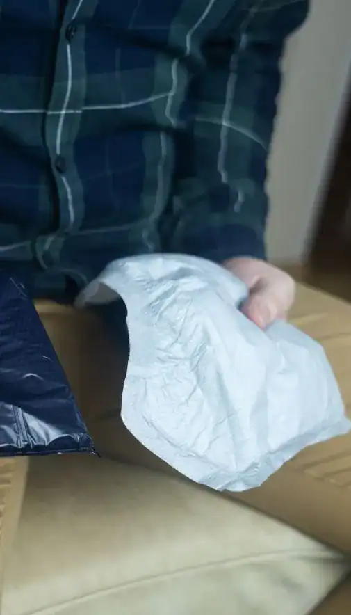 Image of man holding incontinence pads as part of overactive bladder treatment UK